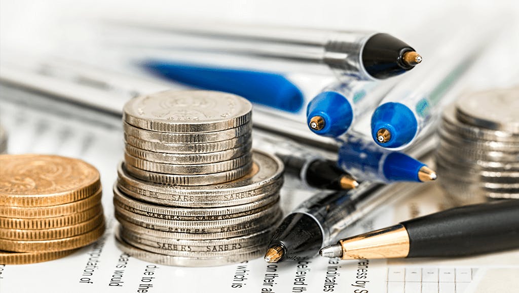 Kassennachschau Finanzprüfung Kleingeld neben Kugelschreibern