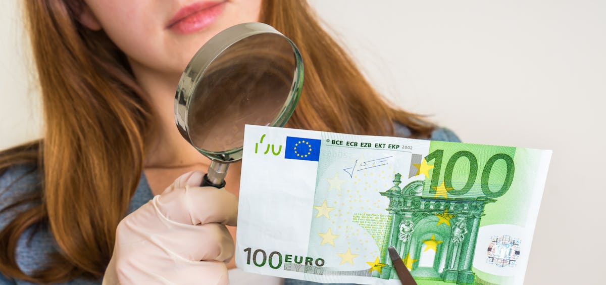 Frau kontrolliert Geldschein Frau kontrolliert Geldschein