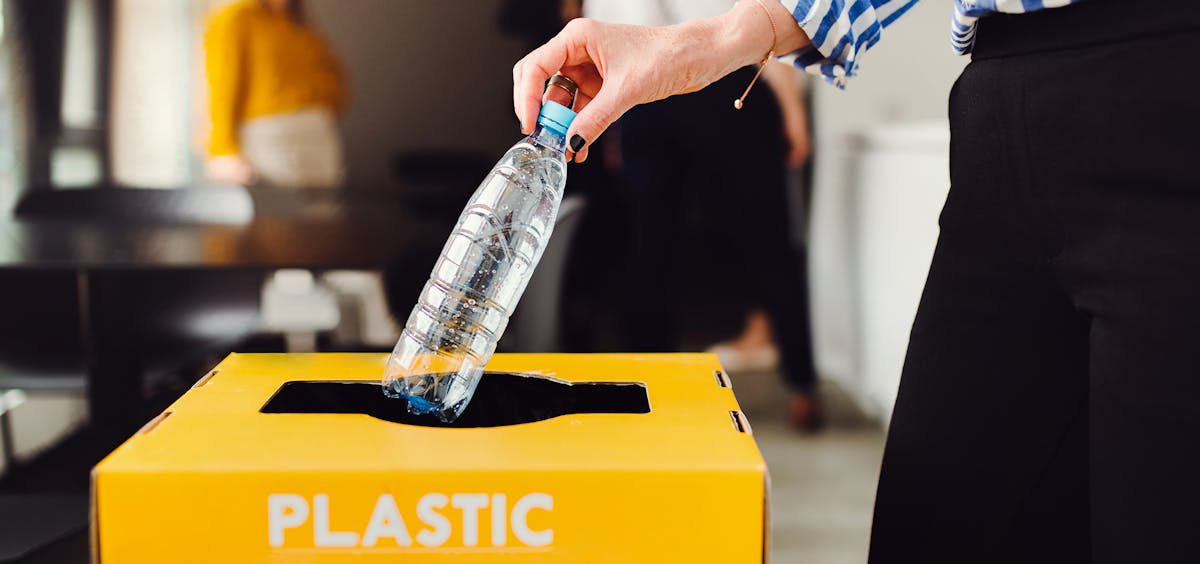 Frau trennt Müll im Büro Frau trennt Müll im Büro