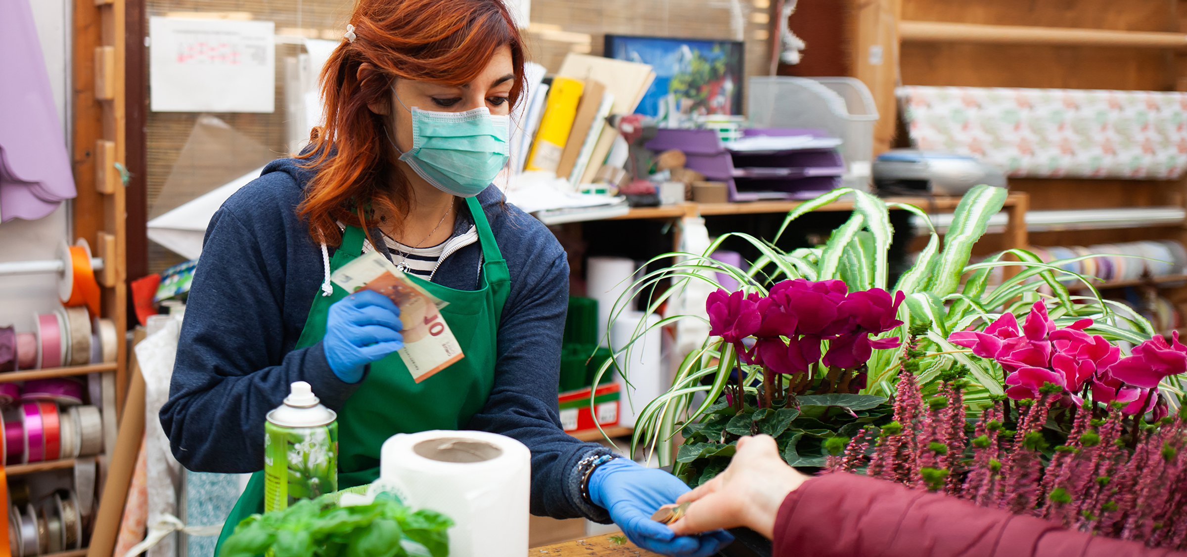 Händlerin mit Maske nimmt Bargeld an