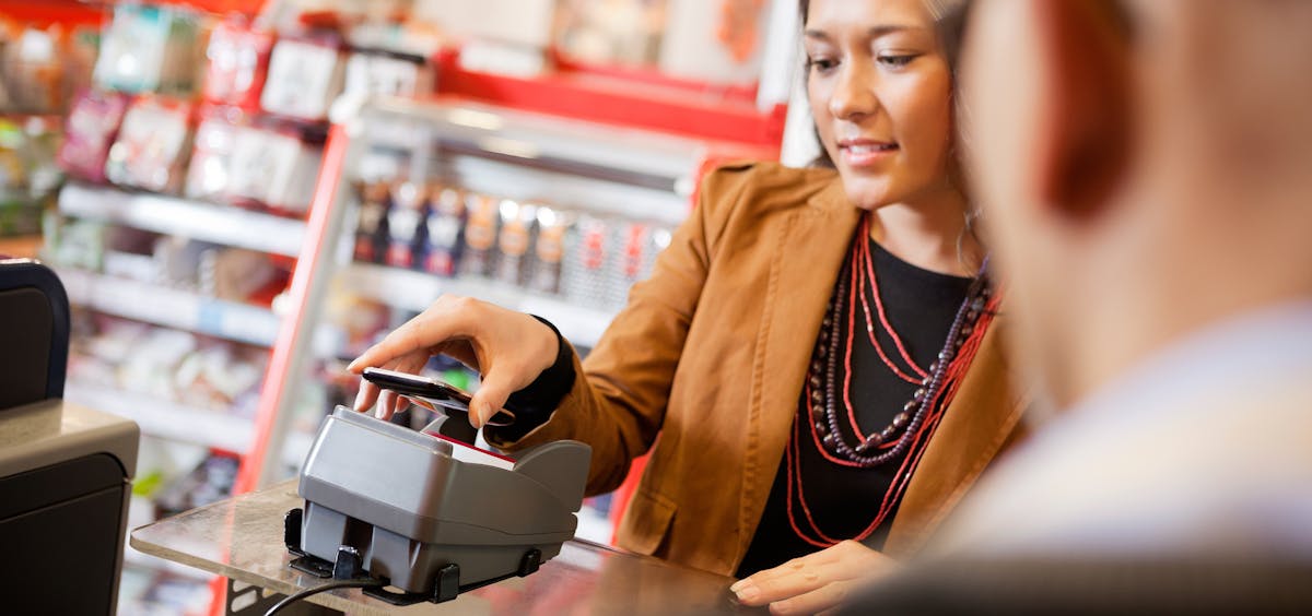 Kundin zahlt mit dem Smartphone Kundin zahlt mit dem Smartphone