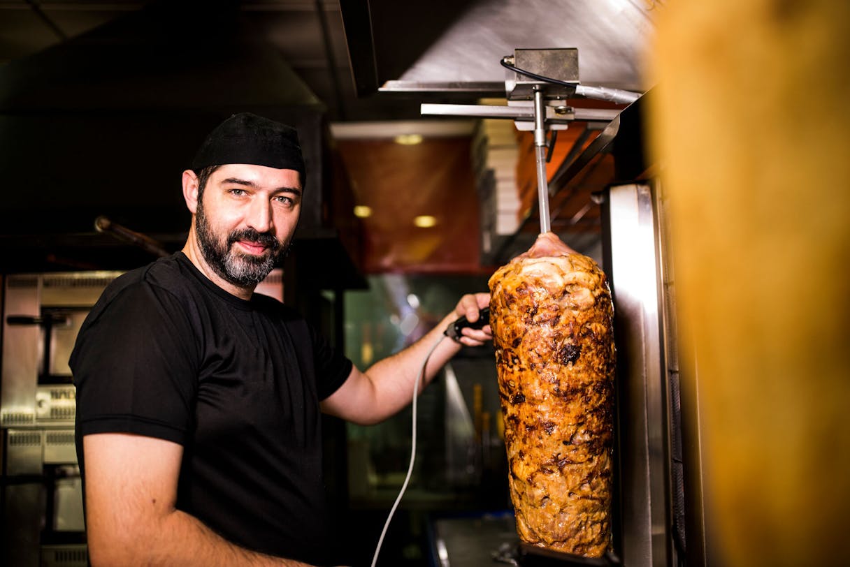 Dönerladen-Besitzer bei der Arbeit Dönerladen-Besitzer bei der Arbeit