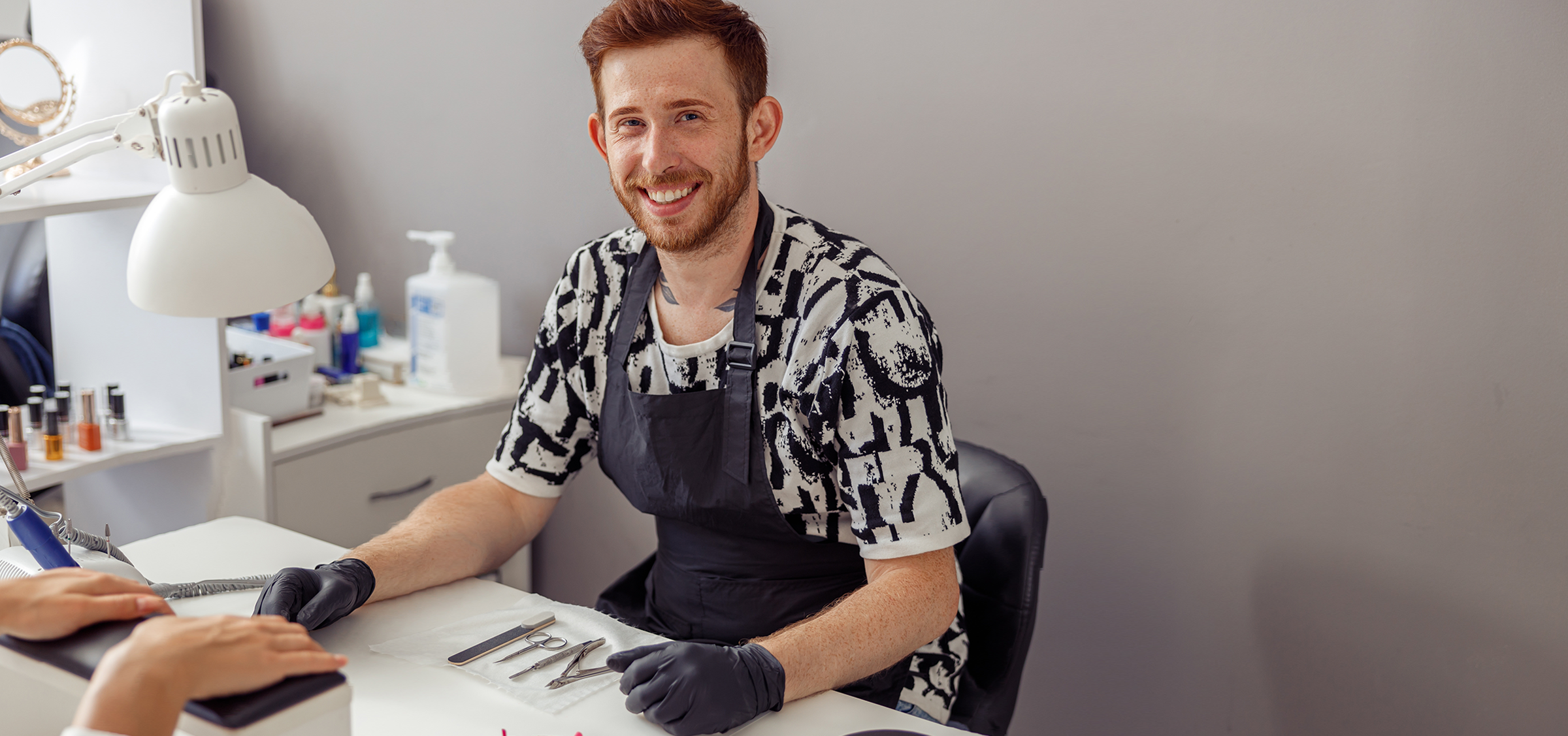 Glücklicher Naildesigner am Arbeitsplatz