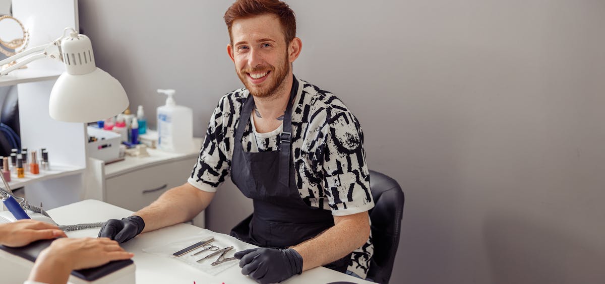 Glücklicher Naildesigner am Arbeitsplatz Glücklicher Naildesigner am Arbeitsplatz