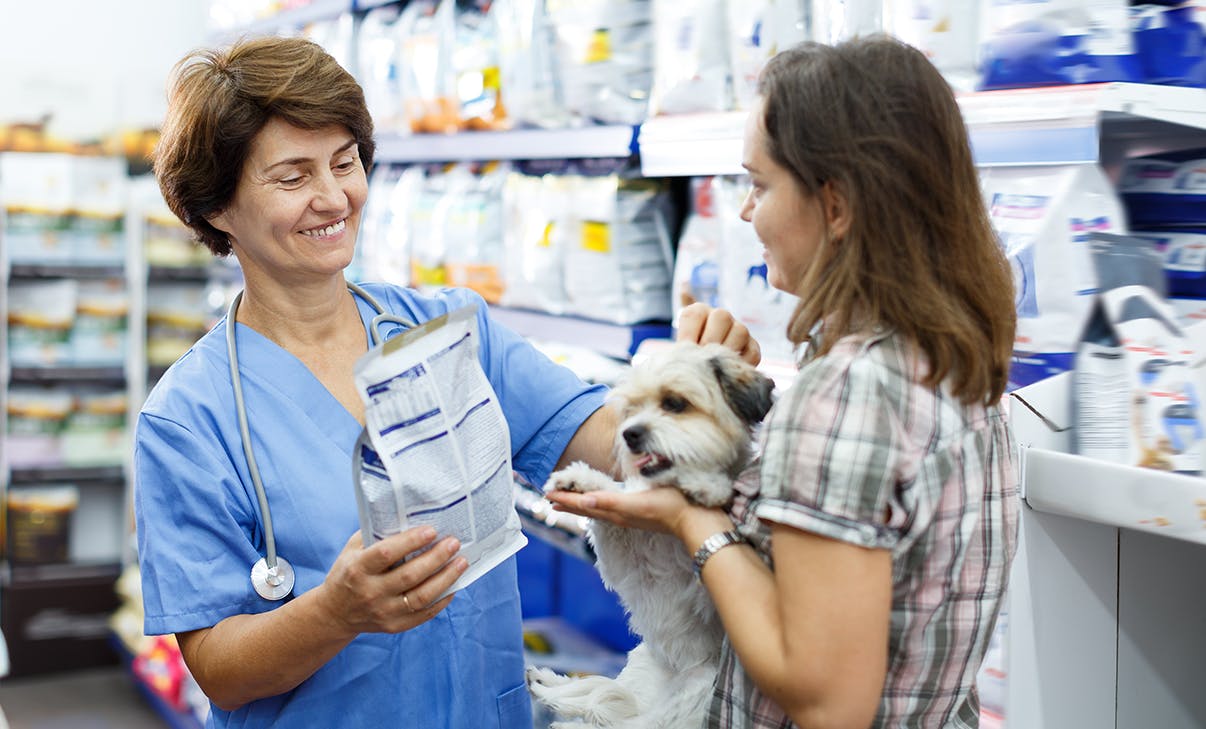 Verkäuferin mit Kundin und Hun Verkäuferin mit Kundin und Hun