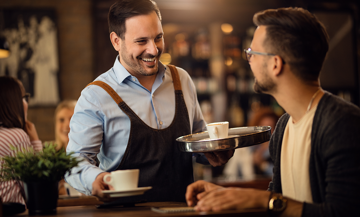 Kellner und Gast am Tisch