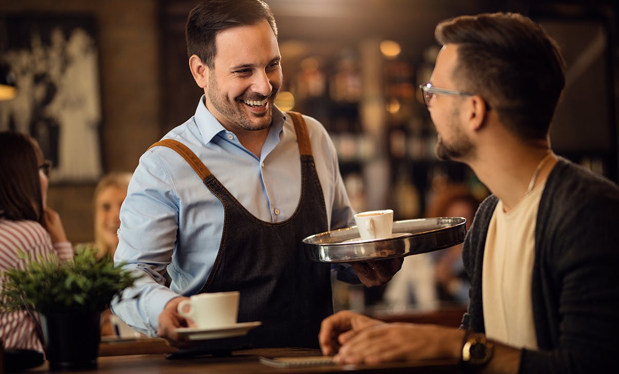 Kellner und Gast am Tisch Kellner und Gast am Tisch