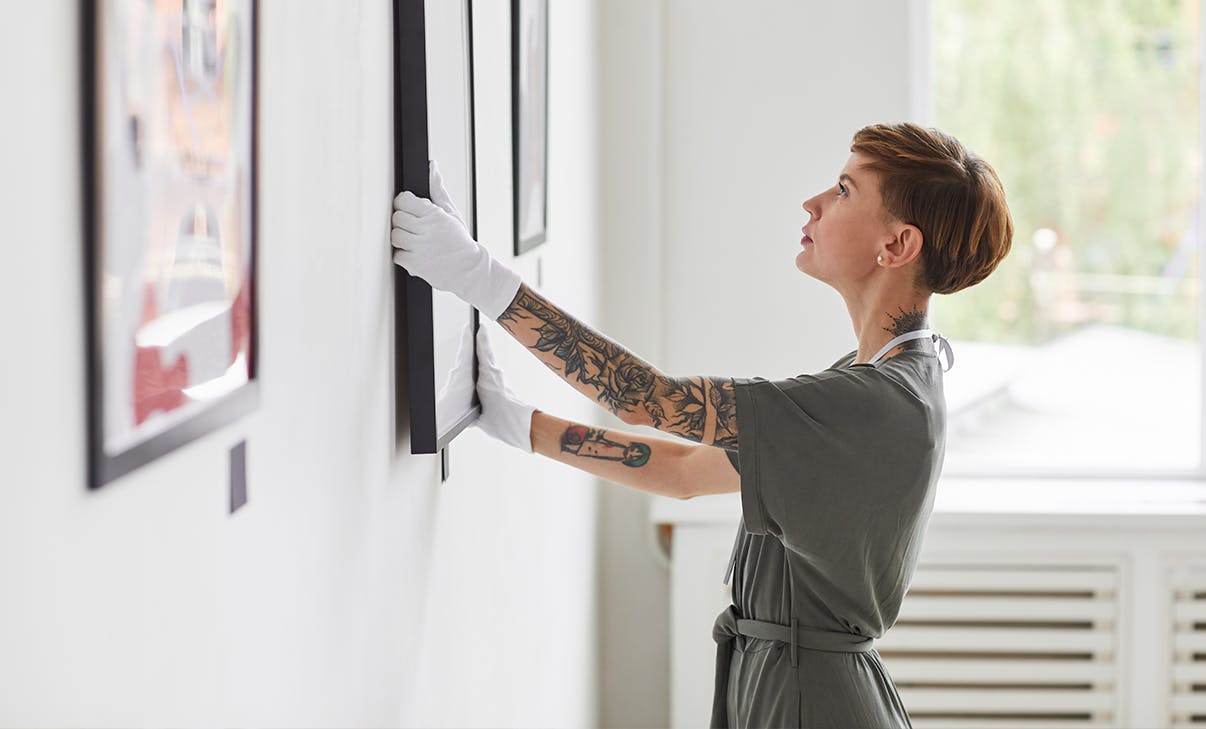 Galeristin hängt Bild auf Galeristin hängt Bild auf