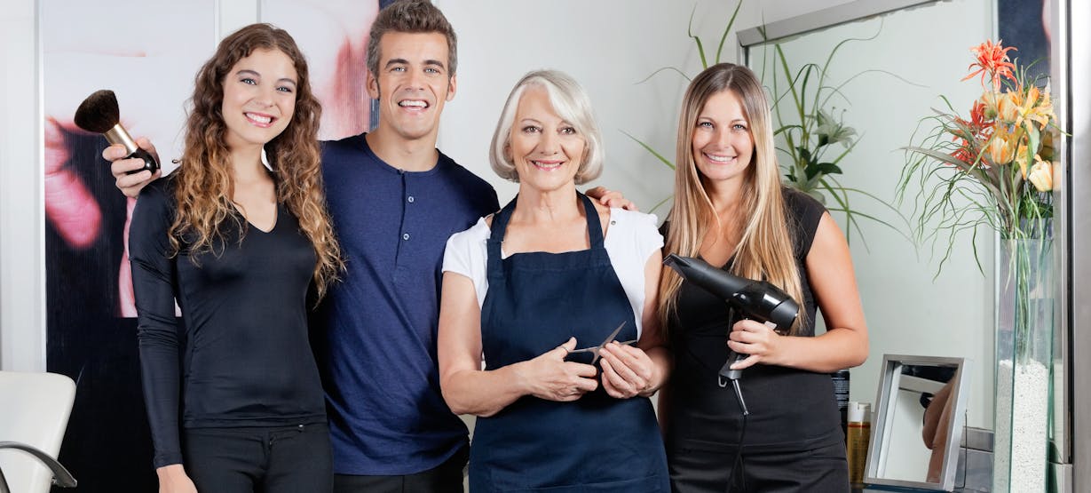 Friseur mit Angestellten im Salon Friseur mit Angestellten im Salon