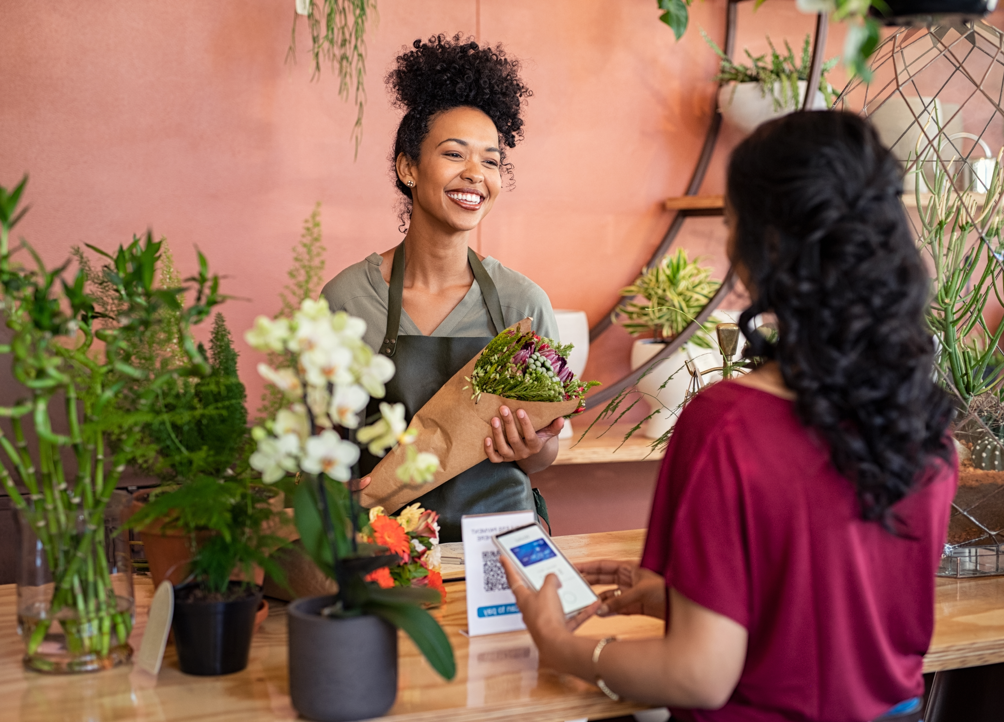 Kundin mit Handy an der Kasse