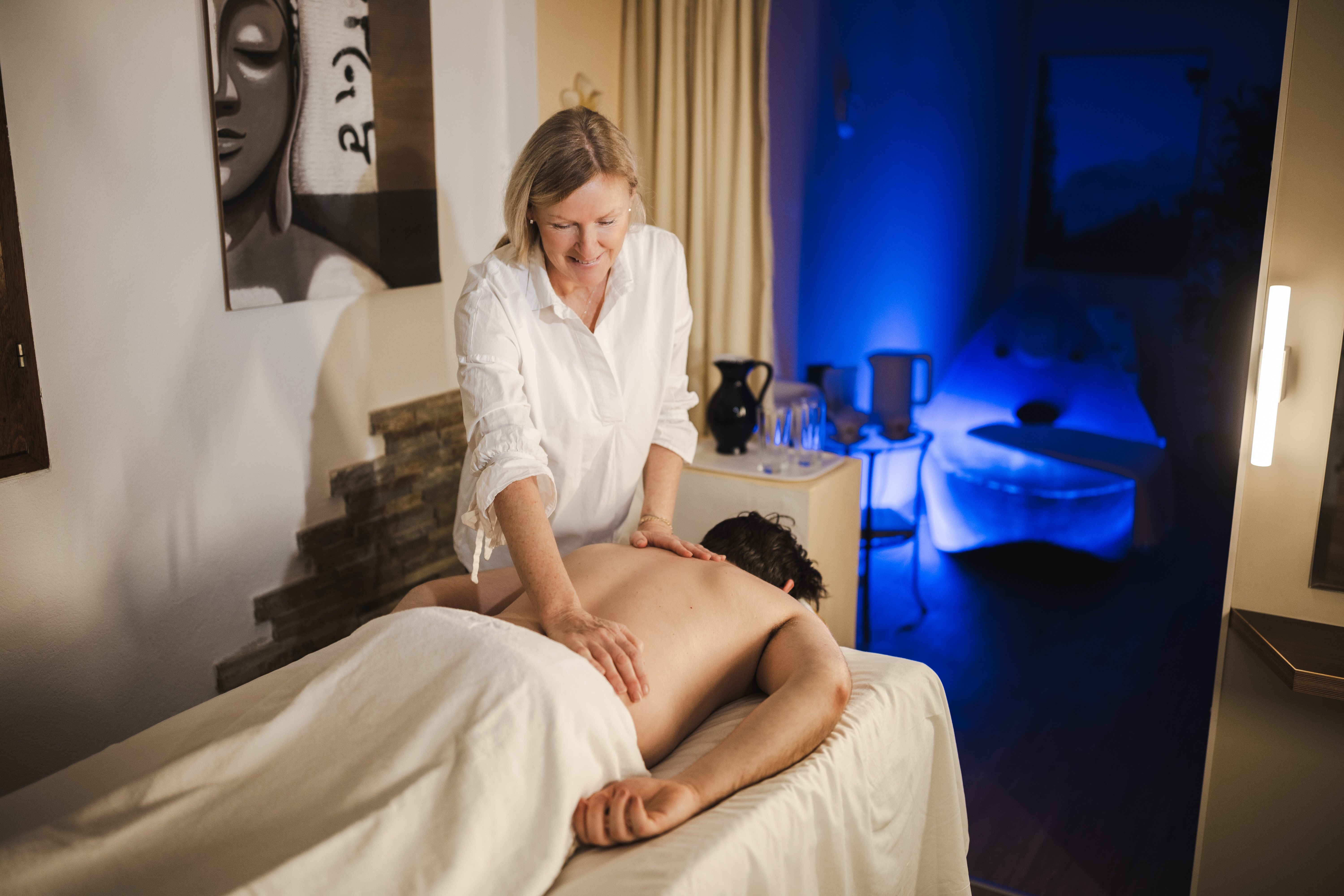 Woman massages client in spa